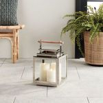 Outdoor lantern on tiled patio floor surrounded by rattan furniture and potted fern