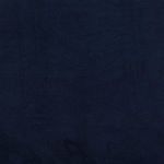 Low-profile navy velvet sofa angled to show tufting and slim wooden legs