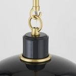 Close-up of aged brass rings and hooks attaching glossy black pendant shade to hanging rod