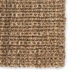 Close-up on chunky thick weave and knotted edge of taupe natural fiber rug