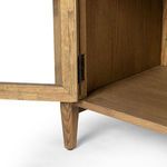 Close-up of one glass door frame with antique brown roller mechanism at the bottom corner