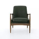 Front view showing chair’s arched arms and plush seat cushion in green leather