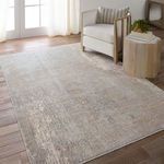 Rug styled in a sunlit room with wooden floor, neutral armchair, striped pillow, and small wood side table
