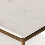 Close-up on nightstand marble top angled to show surface and brass frame edge