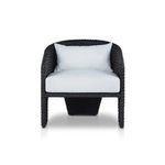 Three-quarter view highlighting barrel back and thick wicker weave with white cushions