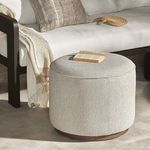 Ottoman placed on patio floor styled next to outdoor sofa with book and fan on top