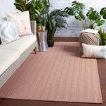 Rug styled in a bright indoor patio with wicker couch and leafy green plants
