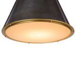 Close-up of diffuser shade showing frosted glass with natural brass rim and warm light glow