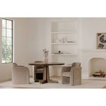 Dining area with two beige Mesto chairs placed around round dark wood table on carpet