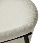 Close-up of armrest corner with cream upholstery overlapping dark wooden support