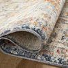 Rug edge folded over highlighting low pile texture and backing at wooden floor