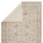 Back side of rug partially folded, revealing solid cream backing with pattern visible from front.