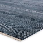 Close-up angle showing the textured plush pile and intricate woven pattern in dark blue and ivory