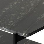 Detailed close-up of rounded edge on polished black marble shelf with iron frame underneath