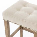 Close-up top corner of seat showing nailhead trim and tufted sand-toned cotton canvas fabric