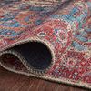 Edge of the Loren rug slightly curled to show texture and underside of the rug on wooden floor