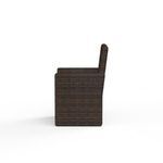Side profile highlighting chair’s thick armrest and flat backrest in Cognac resin wicker