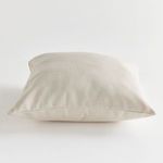 Pillow laying flat with a focus on subtle fabric weave and cushioned thickness