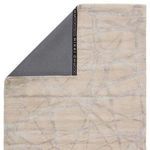 Back corner flipped showing dark gray branded rug backing with wool front