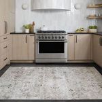Rug placed in a kitchen setting in front of a stainless steel stove with wooden cabinetry surrounding it