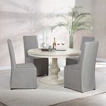 Similar room angle featuring four gray chairs and wine glasses styling on the table