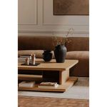 Styled living room setting with Casey table holding vases and books on light cream rug