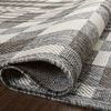 Close-up of folded Rainier Ivory / Pebble Rug showing textured polypropylene weave and edge binding.
