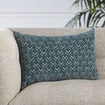 Blue diamond lattice lumbar pillow placed in a sofa corner against pale upholstery