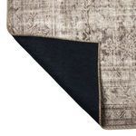 Corner of rug lifted showing solid black underside backing