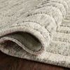 Curled corner close-up revealing texture, pile density, and woven rug backing