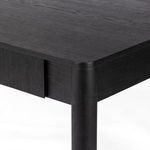 Close-up showing open drawer with metal runner beside rounded leg
