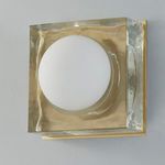 Side angled square sconce shows hammered texture on aged brass frame and frosted glass globe