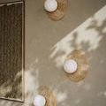 Three Apricity Wall Sconces mounted on a wall with shadows and adjacent abstract artwork
