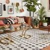 Side-angle view of Yeshaia rug in living room setting with decorative pillows and plants around