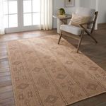 Sahel rug styled in a light room with wood flooring, chair, and small table near French doors