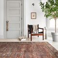 Rug in a minimalistic room featuring a wooden chair, potted plant, and light gray door