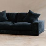 Angled view of dark navy Plunge Sofa revealing armrest and cushion texture in natural room setting