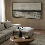 Terrain By Matera painting hanging above beige sectional sofa in softly lit living room with wooden round table