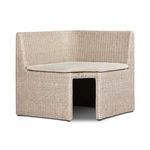 Corner angle view showing curved rattan frame and beige cushion shaped to fit corner space