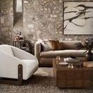 oatmeal pillow styled on beige sofa in rustic living room with stone wall and wood coffee table
