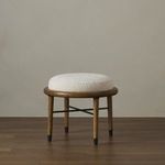 Ottoman styled in a neutral room setting with wood floor and taupe wall background