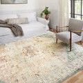 Rug shown in bright room with white couch and armchair, edges and patterns visible from angled view