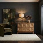 Musashi Walnut console table styled in a dark room setting with a lamp, artwork, and a velvet armchair.