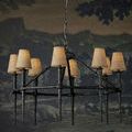 Blackthorn Chandelier with tan fabric lamp shades hanging against a dark themed wallpaper interior