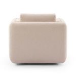 Left side view of chair showing clean lines and rounded silhouette in cream fabric