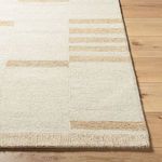 Close-up top view of Max rug corner with textured edge on a light wood floor