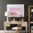 Styled room setting with Hunter Desk against dark wall, pink and gold decor, and natural bamboo chair