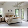 Summerland Bed in bright setting with cream bedding, golden throw, and two furry ottomans at foot
