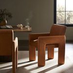 Amur Dining Armchair styled in sunlit dining room with walnut table and carpeted floor