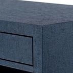 Close-up of textured navy blue lacquered grasscloth surface on the side table corner